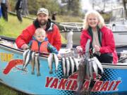 Jason Resser, (left) his son Zayn, and Maggie Ramsey show off their catch from last year’s trout opener at Rowland Lake. The official lowland lakes trout opener is this Saturday. Some 12 million trout and kokanee have been stocked since fall in Washington’s lakes.