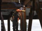 A welder works on a brace frame on the sixth floor of the seven-story office tower at the Vancouver waterfront in March. An upsurge in construction positions helped drive a 400-job increase in seasonally adjusted Clark County employment in March.
