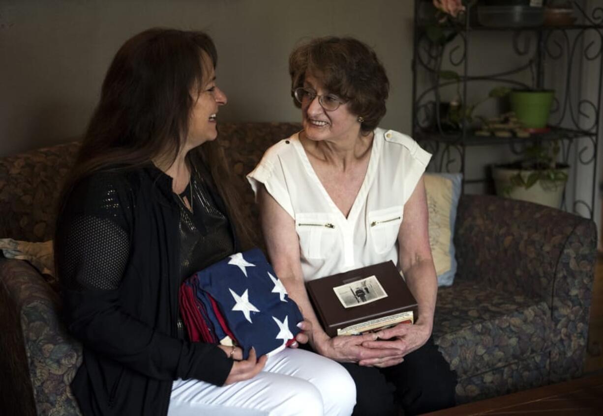 Yvonne Ortega, left, and her mother, Barbara Jo Payne, both of Vancouver, hold Wathen Curtsinger’s ashes and memorial flag Monday at Payne’s home. Curtsinger, Payne’s father and Ortega’s grandfather, was a World War II Marine veteran. He died in 1996, and his ashes were lost in 2002, stolen during a family move. Marine veteran Bill Malloy, a member of Veterans of Foreign Wars Post 1927, was the link between the family and the Woodland Police Department.