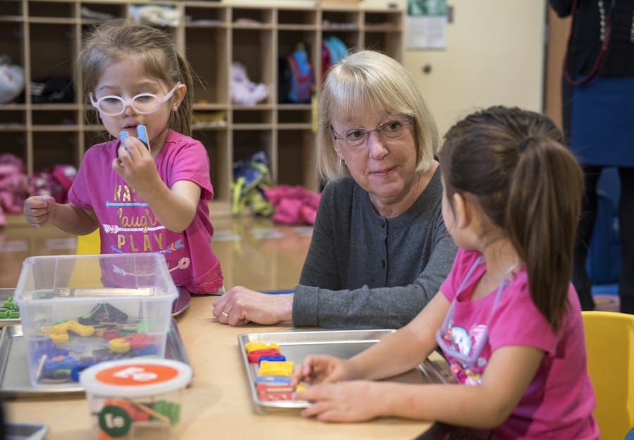 Sen. Patty Murray visits with Alivia Estrada-Houghton, left, and her twin Alayna, right, both 2 and of Vancouver, at the Hough Early Learning Center.