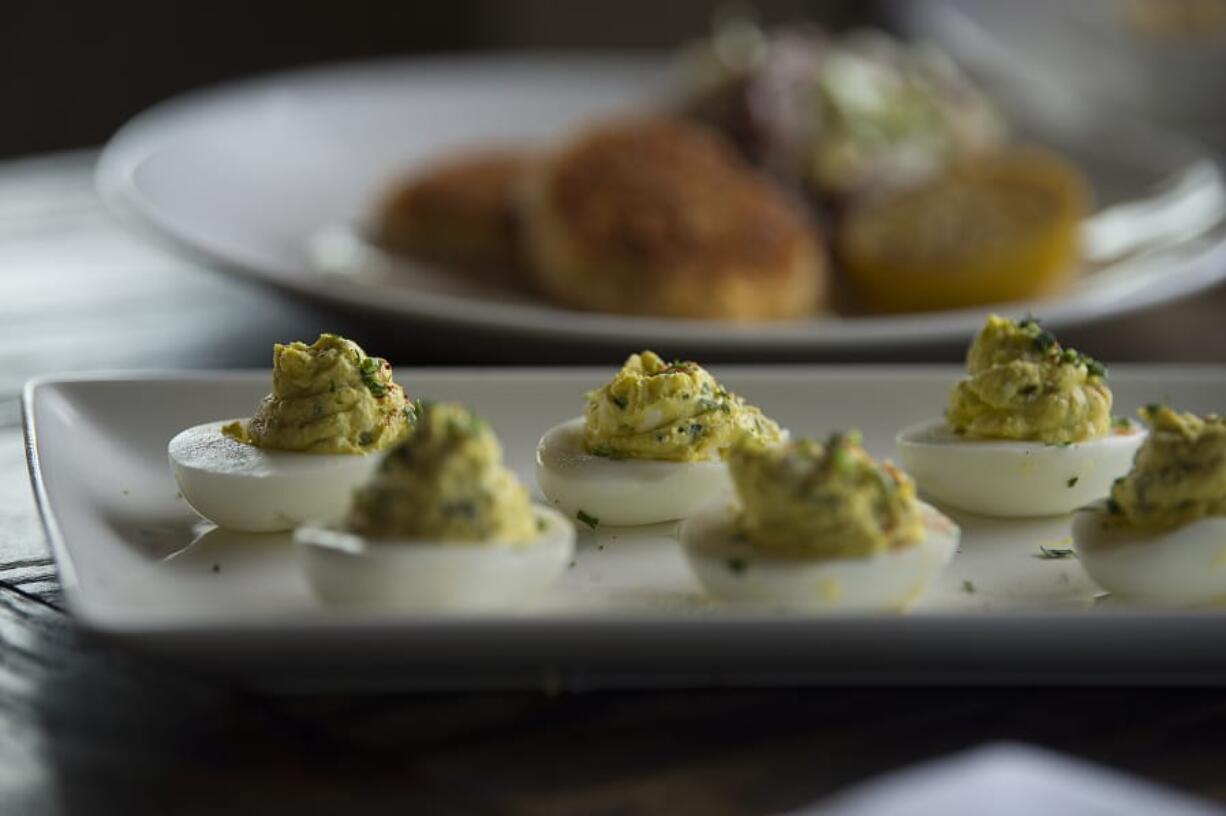 Amanda Cowan/The Columbian Appetizers at The Hammond Kitchen & Cafe Bar in Camas include deviled eggs, foreground, and delicious red rock crab cakes.