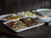 Amanda Cowan/The Columbian The ribeye steak, center, at the Hammond Kitchen & Craft Bar in Camas tastes delicious and can be accompanied by a bevy of side dishes, clockwise from left, including crab cakes, deviled eggs, clam chowder and crustless coconut creme pie.