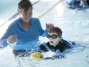 Occupational therapist Karen Drogos, left, helps Gary Silvas, 5, swim to capture a ball during a water-based physical therapy session at the Marshall Center. Gary was a micro-preemie and weighed just 1 pound, ½ ounce at birth.