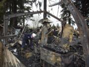 Clark County fire officials, fire inspector Rick Searls, left, and deputy fire Marshall Caleb Barnes, right, investigate the scene of a fire at the Malt Shop and Grill and the Chicken and Rib House booths at the Clark County Fairgrounds on Wednesday morning, April 11, 2018.