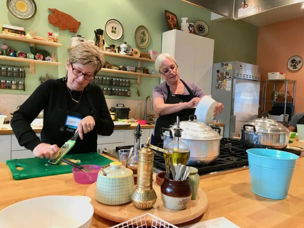 Lynn Peterson, left, and Kim Mahan take part in a dim sum class at Class Cooking.