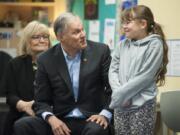 Gov. Jay Inslee talks to third-grader Anaiyah Andre, 9, before naming her Washingtonian of the Day, recognizing her for her creative answer to a question he’d asked. Inslee, a Democrat, kicked off a Monday visit to Vancouver with a stop at Fruit Valley Community Learning Center to talk about the Breakfast After the Bell bill and learn what the school is doing to support students and the community. First lady Trudi Inslee is seated behind her husband.