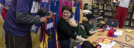 Manu Iyer, with the Harlem Wizards, presents Lauren Reagan with team jersey for her and her husband, Francis Reagan. Their twin sons, Declan and Adrian, were signed by the team during a ceremony Wednesday morning. Declan recently started hospice care after a two year fight with leukemia.