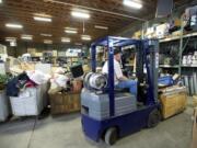 Warehouse workers organize donated goods at the ARC storage facility in 2014. The organization hopes to open a retail space in Vancouver Plaza, which is less than a mile from the storage warehouse.