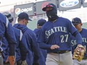 Seattle Mariners' Ryon Healy goes through the celebration line after the Mariners defeated the Minnesota Twins 11-4 in a baseball game Saturday, April 7, 2018, in Minneapolis.