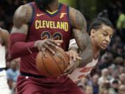 Cleveland Cavaliers' LeBron James, left, drives past New York Knicks' Trey Burke in the first half of an NBA basketball game, Wednesday, April 11, 2018, in Cleveland.