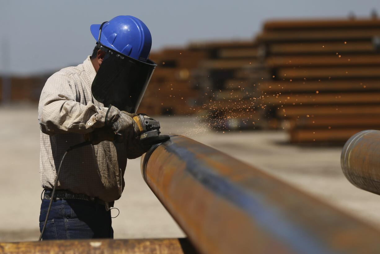 Jose Mata grinds a steel pipe at the Borusan Mannesmann plant in Baytown, Texas, Monday, April 23, 2018. President Donald Trump's escalating dispute with China over trade and technology is threatening jobs and profits in working-class communities where his "America First" agenda hit home. Without a waiver, Borusan Mannesmann Pipe may face tariffs of $25 million to $30 million annually if it imports steel tubing and casing from its parent company in Turkey, according to information the company provided to The Associated Press.