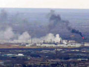 This image from video provided by WDIO-TV in Duluth shows smoke rising from the Husky Energy oil refinery after an explosion Thursday morning, April 26, 2018 in Superior, Wis. Authorities say several people were injured in the explosion.