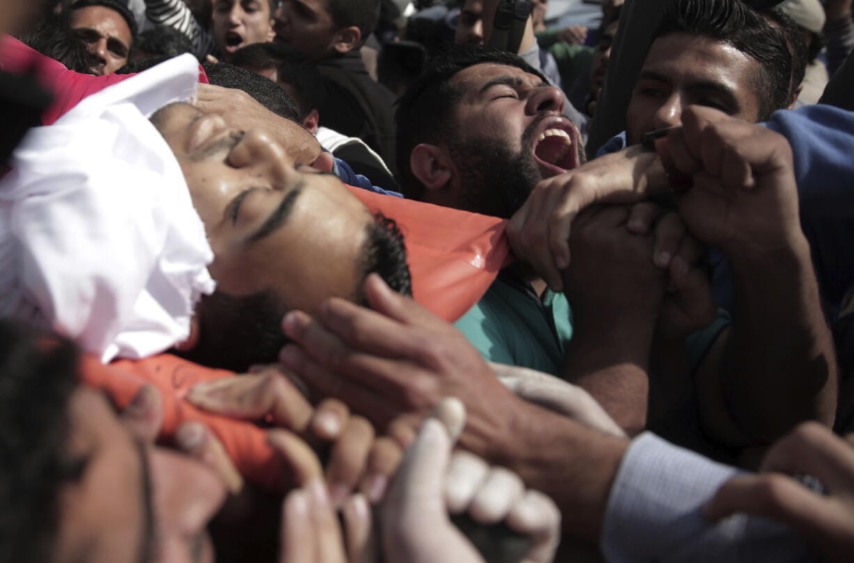 Mourners carry the body of Palestinian cameraman who was shot and killed, Friday by Israeli troops while covering a protest at the Gaza Strip’s border with Israel, during his funeral in Gaza City, Saturday, April 7, 2018.