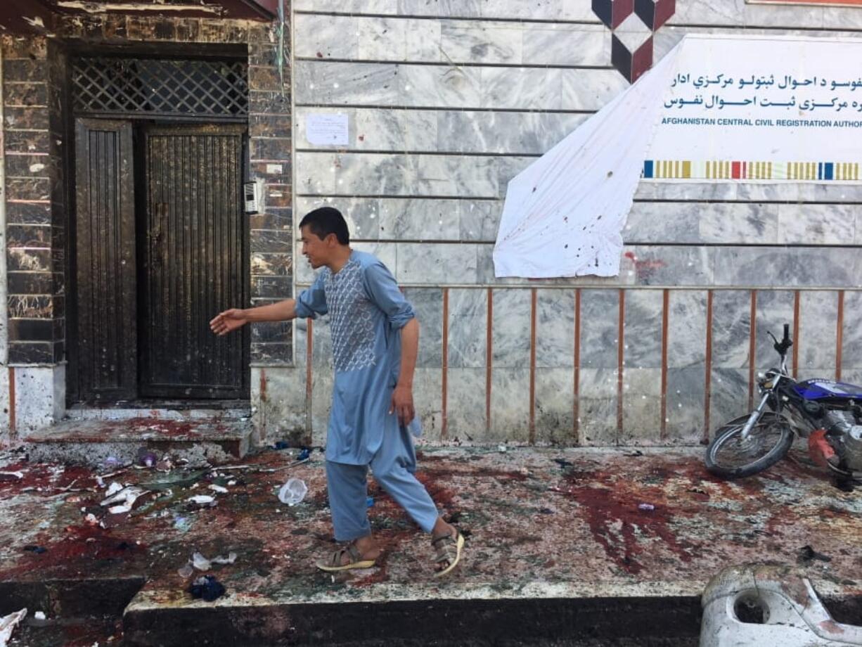 An Afghan man walks outside a voter registration center Sunday, which was attacked by a suicide bomber in Kabul.