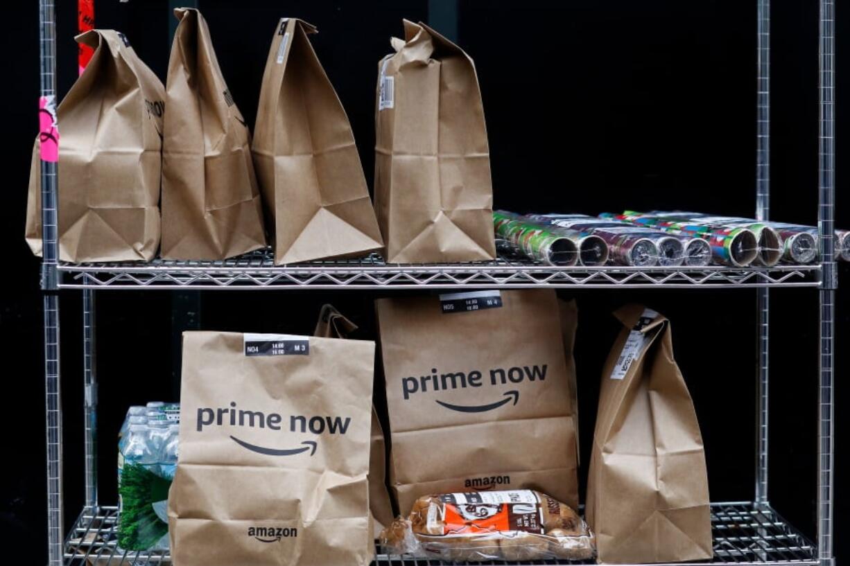 File- This Wednesday, Dec. 20, 2017, file photo, shows Amazon Prime Now bags are ready for delivery, at the Amazon warehouse in New York. Amazon says it will hike up the price of its Prime membership fee by 20 percent next month. Prime members in the U.S. will now pay $119 a year, up from $99, starting May 11 for new members.