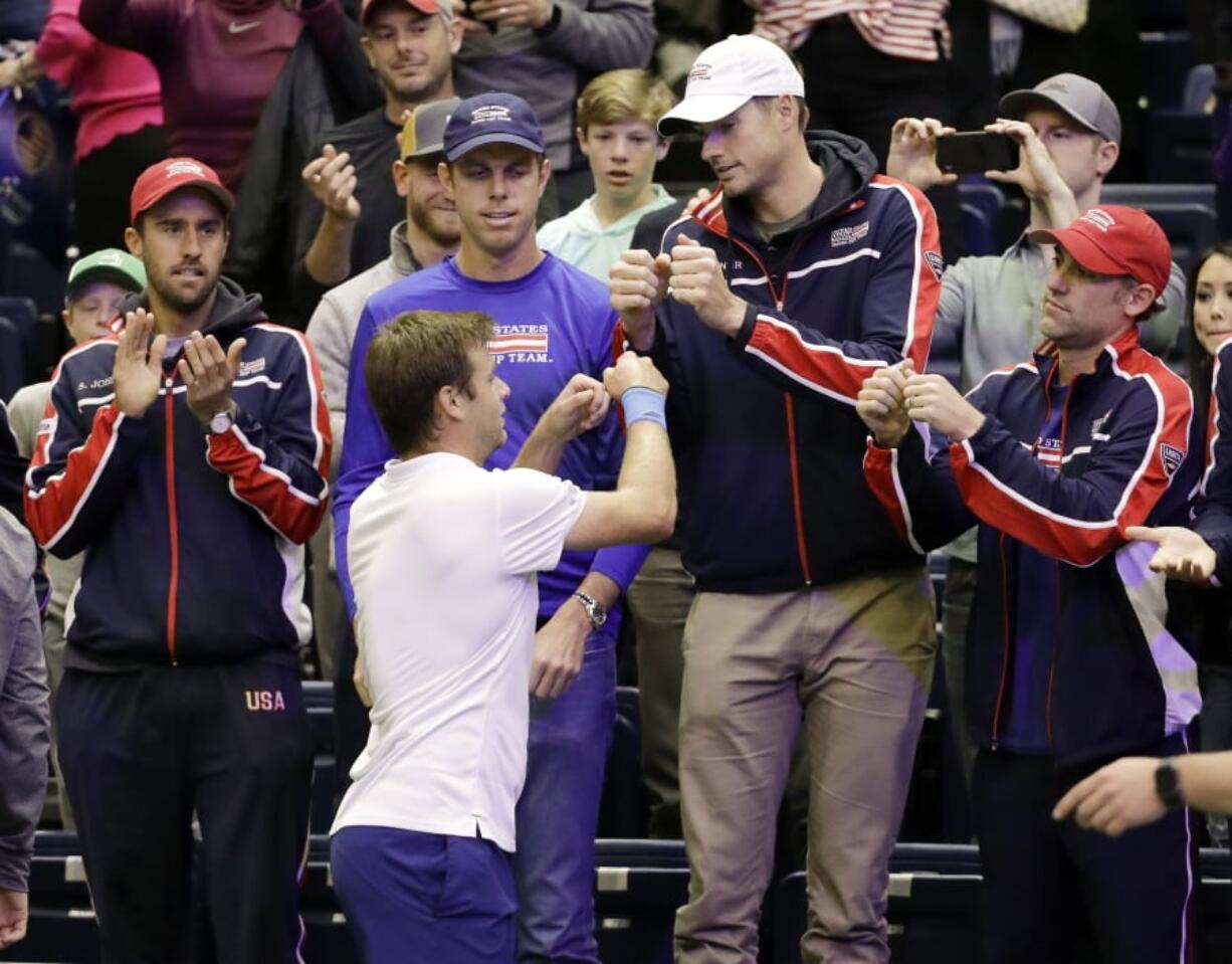 Ryan Harrison, of the United States, celebrates with teammates after beating Ruben Bemelmans, of Belgium, in a Davis Cup quarterfinal singles tennis match Sunday, April 8, 2018, in Nashville, Tenn. The United States clinched the series Saturday to move on to the semifinals.