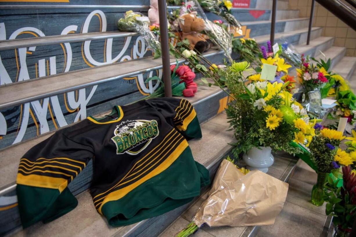 A memorial at the stairs that lead to Elgar Petersen Arena is shown in Humboldt, Saskatchewan, on Saturday, April 7, 2018. Royal Canadian Mounted Police say 14 people are dead and others injured Friday after a truck collided with a bus carrying a junior hockey team to a playoff game in northeastern Saskatchewan. Police say there were 28 people including the driver on board the Humboldt Broncos bus when the crash occurred at around 5 p.m. on Highway 35 north of Tisdale.