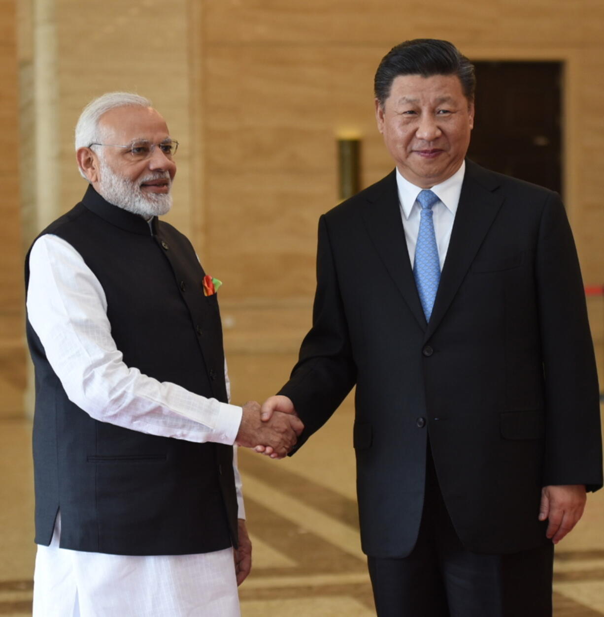 In this photo released by the Indian Ministry of External Affairs, Indian Prime Minister Narendra Modi, left, shakes hands with Chinese President Xi Jinping in Wuhan, China, Friday, April 27, 2018. The leaders of India and China met at a lakeside resort in central China on Friday amid tensions along their contested border and a rivalry for influence among their smaller neighbors that could determine dominance in Asia.