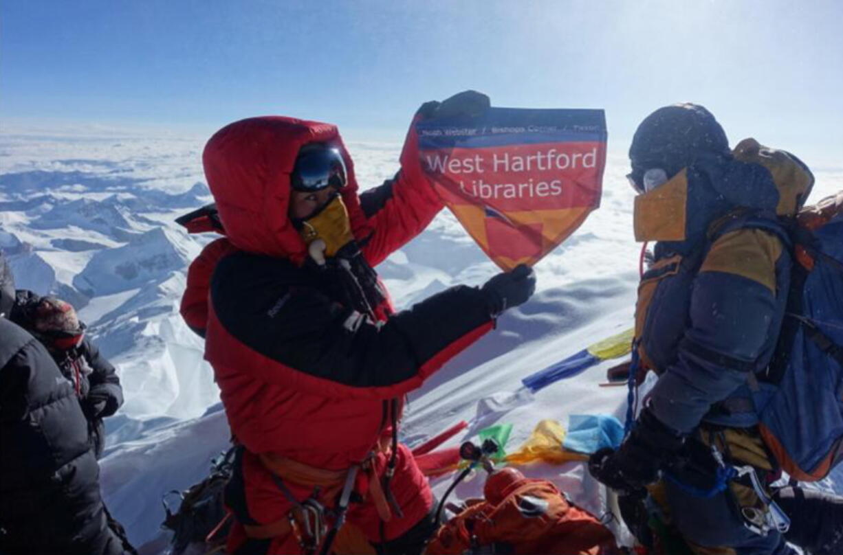 Lhakpa Sherpa displays a flag from West Hartford, Conn., on the summit of Mount Everest in Nepal. Once a year, Sherpa heads back to her native Nepal to try and break her own record for successful summits of Mount Everest by a woman.