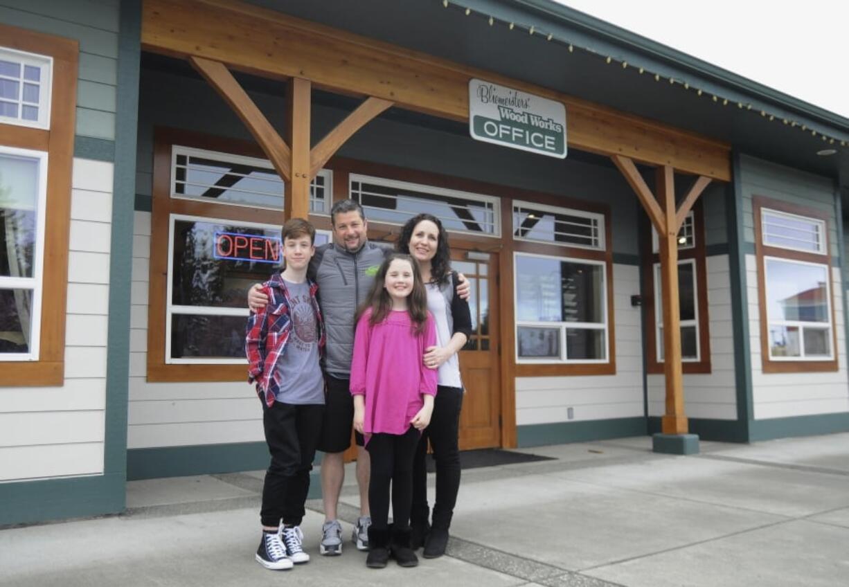 Jason Doig, his wife Jeni and children Ethan 10, and Rylie, 10, stand March 30 outside Doig’s business, Bliemeisters’ Wood Works in Carlsborg. Doig was awarded the Carnegie Medal for heroism.