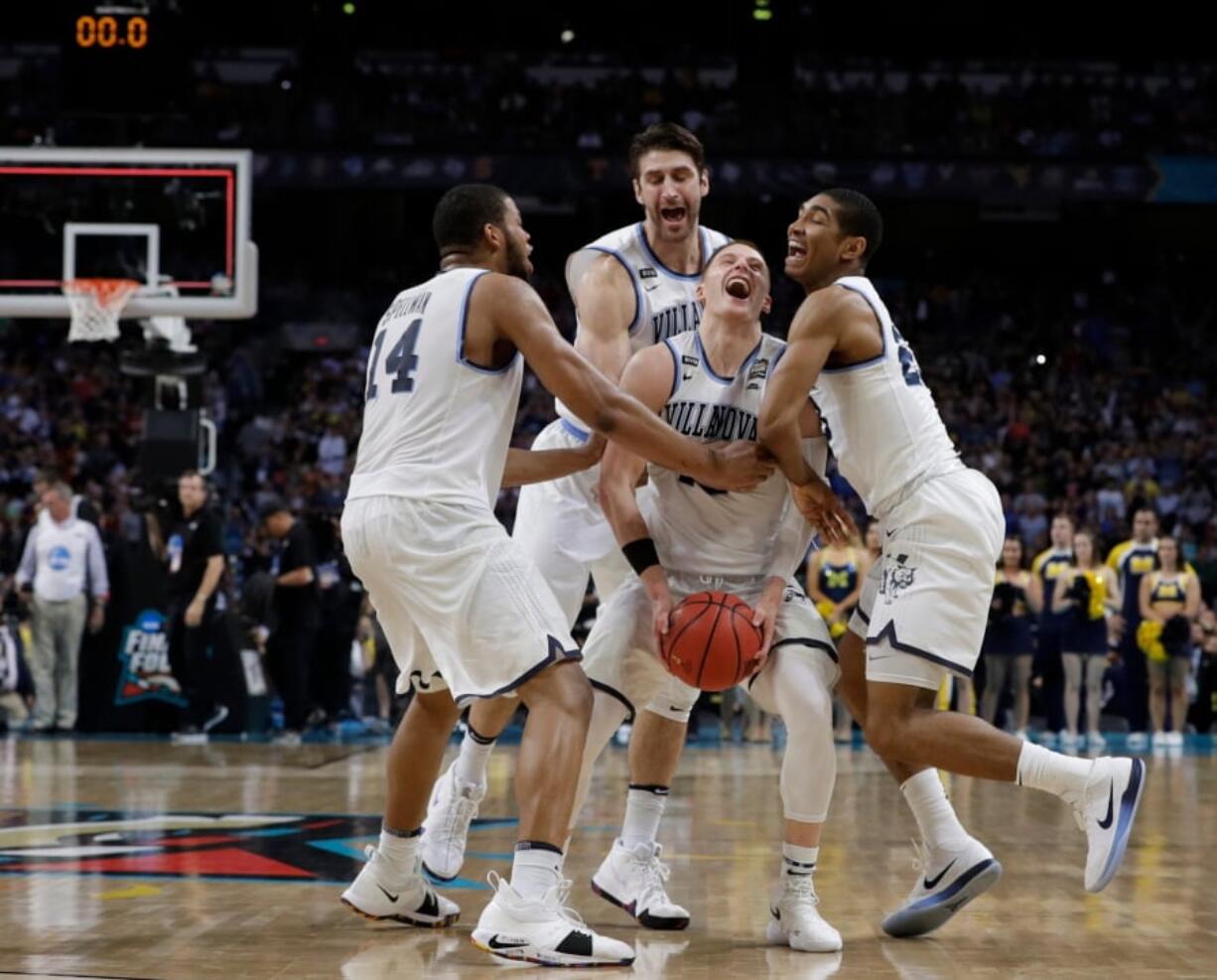 Villanova guard Donte DiVincenzo, center, celebrates with teammates at the end of the championship game against Michigan in the Final Four NCAA college basketball tournament, Monday, April 2, 2018, in San Antonio. Villanova won 79-62. (AP Photo/David J.