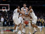 Villanova guard Donte DiVincenzo, center, celebrates with teammates at the end of the championship game against Michigan in the Final Four NCAA college basketball tournament, Monday, April 2, 2018, in San Antonio. Villanova won 79-62. (AP Photo/David J.