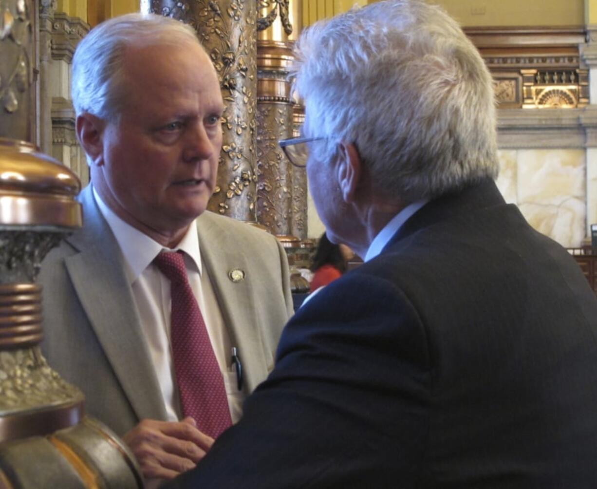 Kansas state Sens. Gene Suellentrop, left, and Mike Petersen, right, both R-Wichita, confer during a debate in the Senate, Saturday April 7, 2018, at the Statehouse in Topeka, Kan. Legislators face a Kansas Supreme Court mandate to increase spending on public schools.