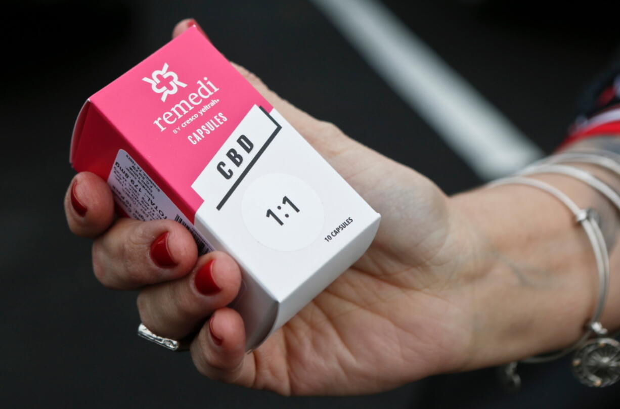 A woman holds the prescribed medical marijuana product used to treat her daughter’s epilepsy after making a purchase at a medical marijuana dispensary in Butler, Pa. Two new studies released on Monday, April 2, 2018 suggest that legalization of marijuana may reduce the prescribing of opioids.