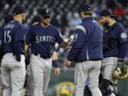 Seattle Mariners starting pitcher Marco Gonzales (32) hands the ball to manager Scott Servais, second from right, during the third inning of a baseball game against the Kansas City Royals at Kauffman Stadium in Kansas City, Mo., Monday, April 9, 2018.