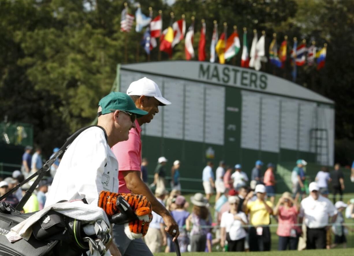 Tiger Woods, right, and caddie, Joe LaCava walk to the ninth green during practice for the Masters golf tournament at Augusta National Golf Club, Monday, April 2, 2018, in Augusta, Ga.