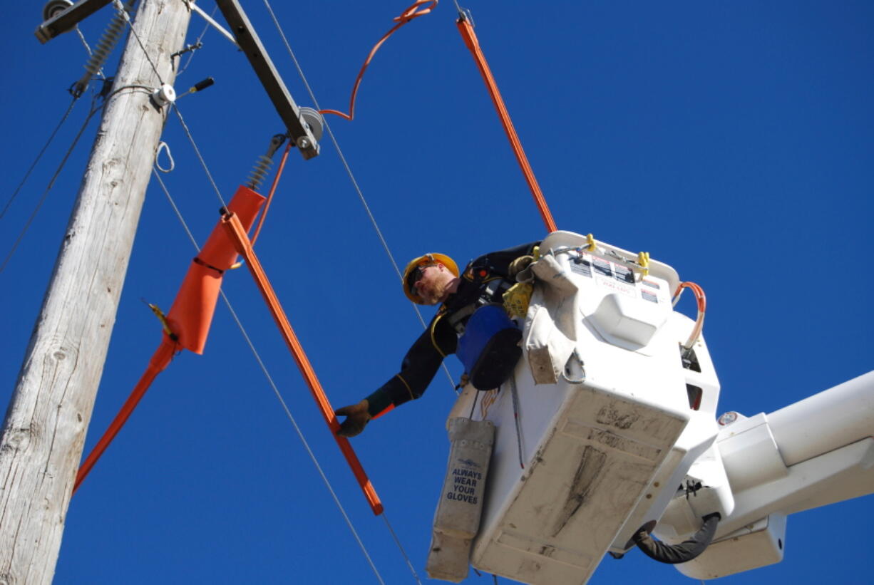 Idaho Power Co. apprentice lineman Claysen Hale prepares to change out jumpers and stirrups on a power line in Eden, Idaho, in 2016. Federal officials have approved new transmission-line routes in the southwestern part of the state.