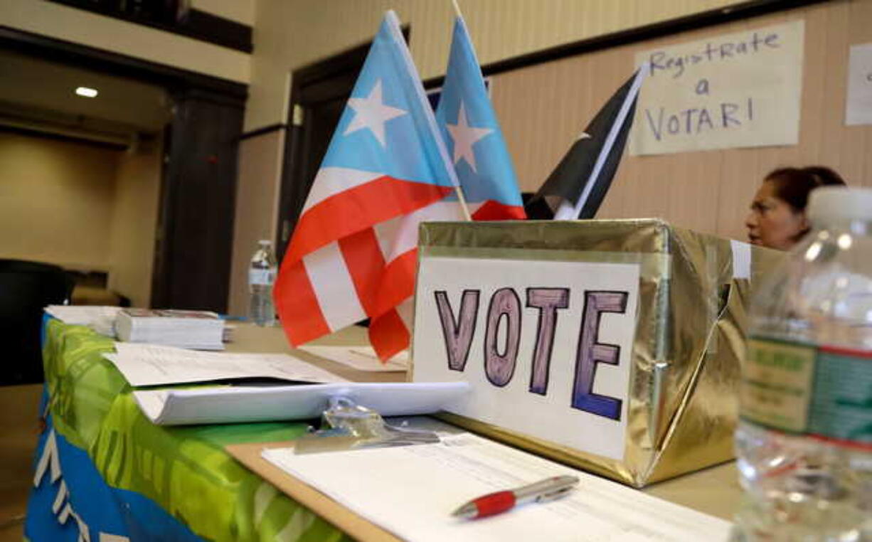 In this April 14, 2018 photo, a voter registration booth stands during an event to help Puerto Rico hurricane victims in Elizabeth, New Jersey. The intensity of political attention ahead of midterm election is new for Puerto Ricans, who are accustomed to not having much political clout.