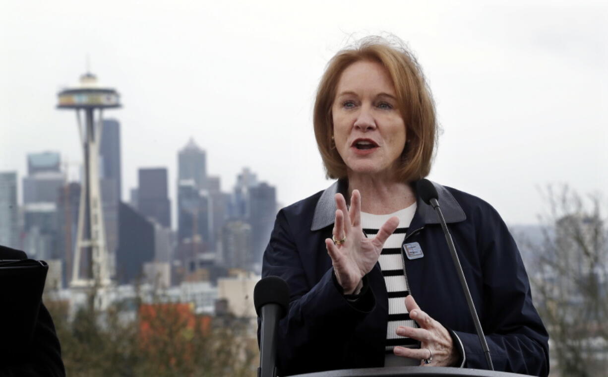 Seattle Mayor Jenny Durkan speaks at a news conference about efforts to reduce greenhouse gases in the city as she stands at a viewpoint looking toward downtown Wednesday in Seattle. Durkan wants to toll some downtown roads to try to ease the city’s traffic gridlock. Such “congestion pricing” is used in some European cities but so far no U.S. city has established such a system.