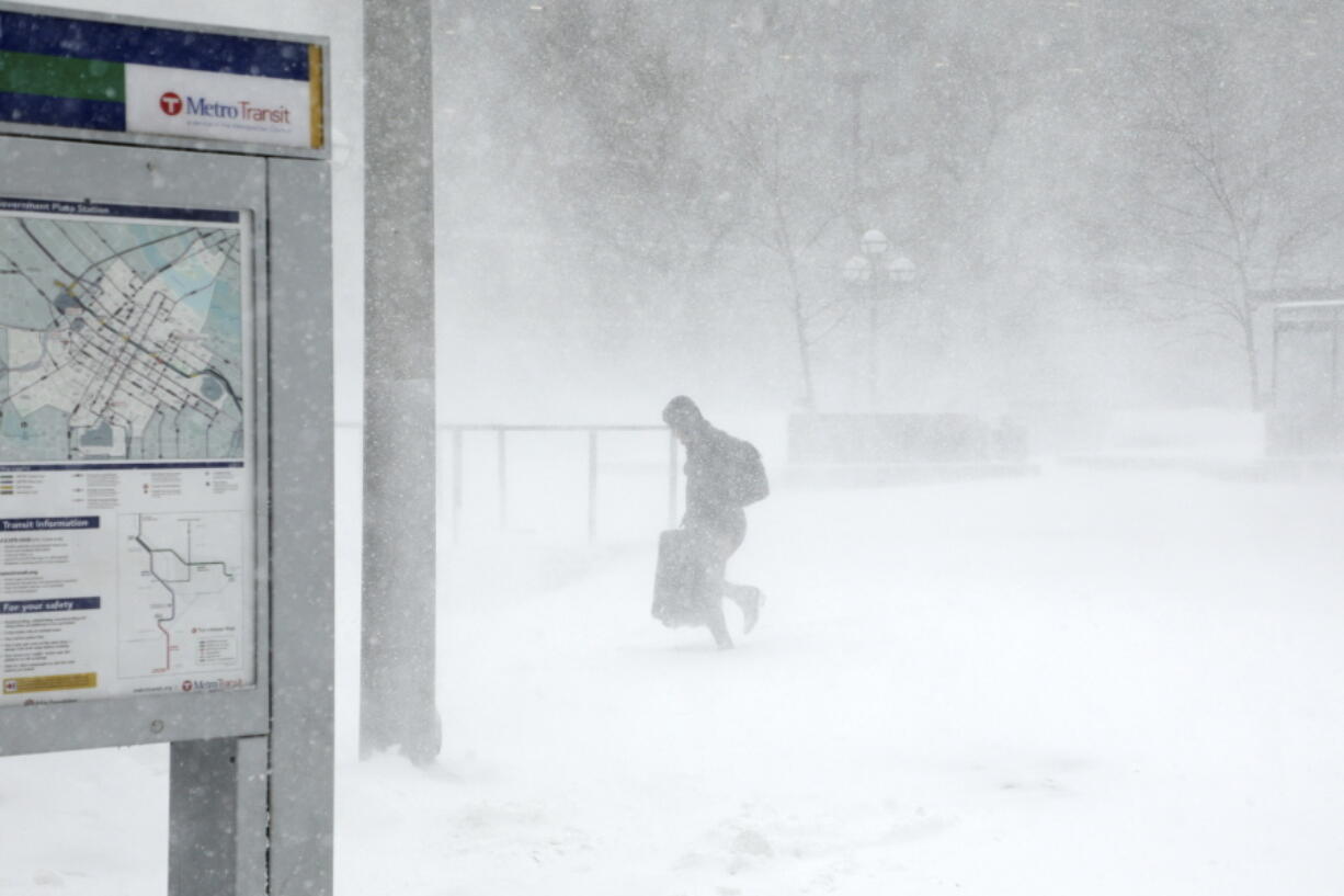 A traveler walks through the snow and ice to get to the Metro Government Center Plaza station as the snow picked up in downtown Minneapolis, Saturday, April 14, 2018. The National Weather Service predicts 9 to 15 inches of snow across a large swath of southern Minnesota including the Twin Cities before it’s all over.