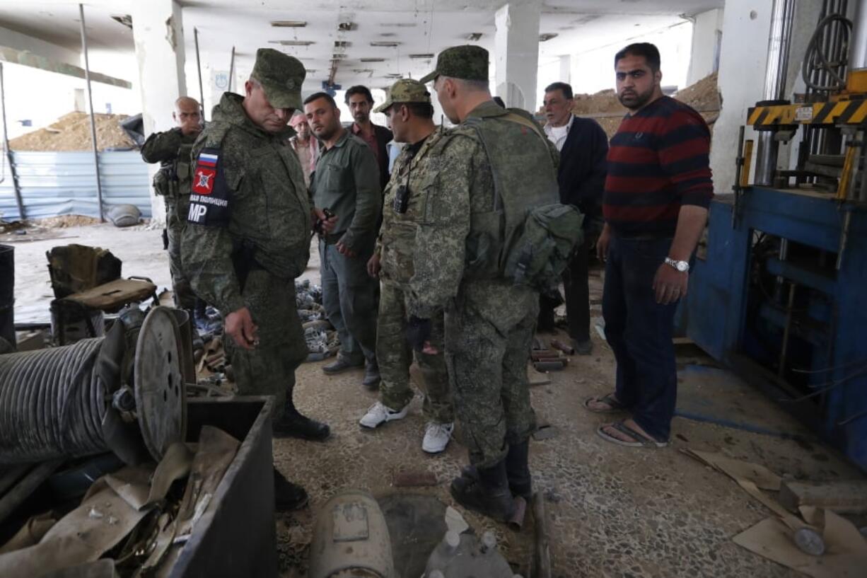 Russian military police officers check weapons left behind by members of the Army of Islam group in a factory produced weapons, in the town of Douma, the site of a suspected chemical weapons attack, near Damascus, Syria, on Monday. Faisal Mekdad, Syria’s deputy foreign minister, said on Monday that his country is “fully ready” to cooperate with the fact-finding mission from the Organization for the Prohibition of Chemical Weapons that’s in Syria to investigate the alleged chemical attack that triggered U.S.-led airstrikes.