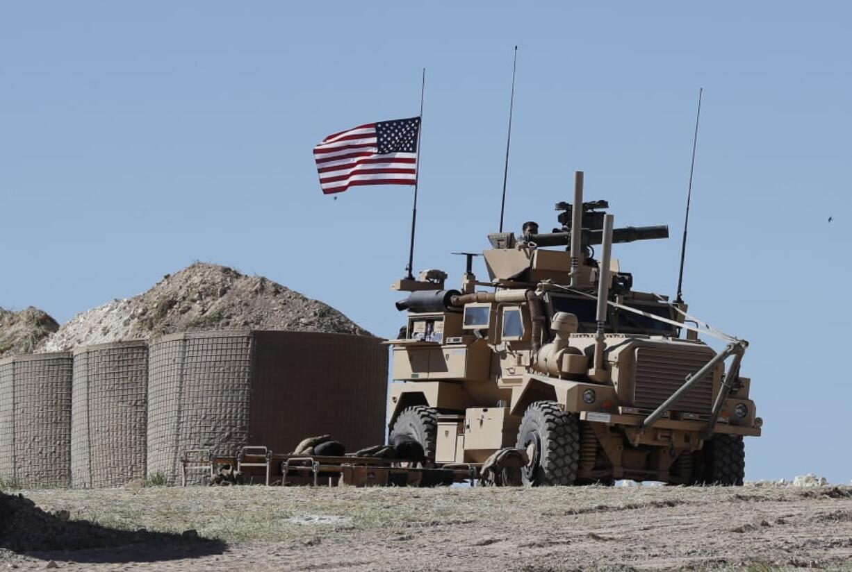 A U.S. soldier sits Wednesday on an armored vehicle at a newly installed position near the tense front line in Manbij, Syria, between the U.S-backed Syrian Manbij Military Council and Turkish-backed fighters.