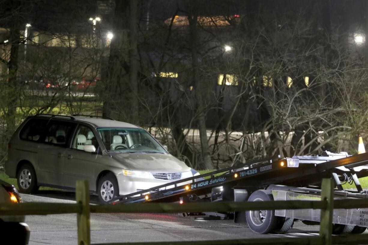 A minivan is removed from the parking lot near the Seven Hills School campus in Cincinnati. Cincinnati authorities are investigating the death Tuesday of 16-year-old Kyle Plush, who was trapped inside the minivan. The Hamilton County coroner says Plush died of asphyxia due to “chest compression” and that it appears to be an accident.