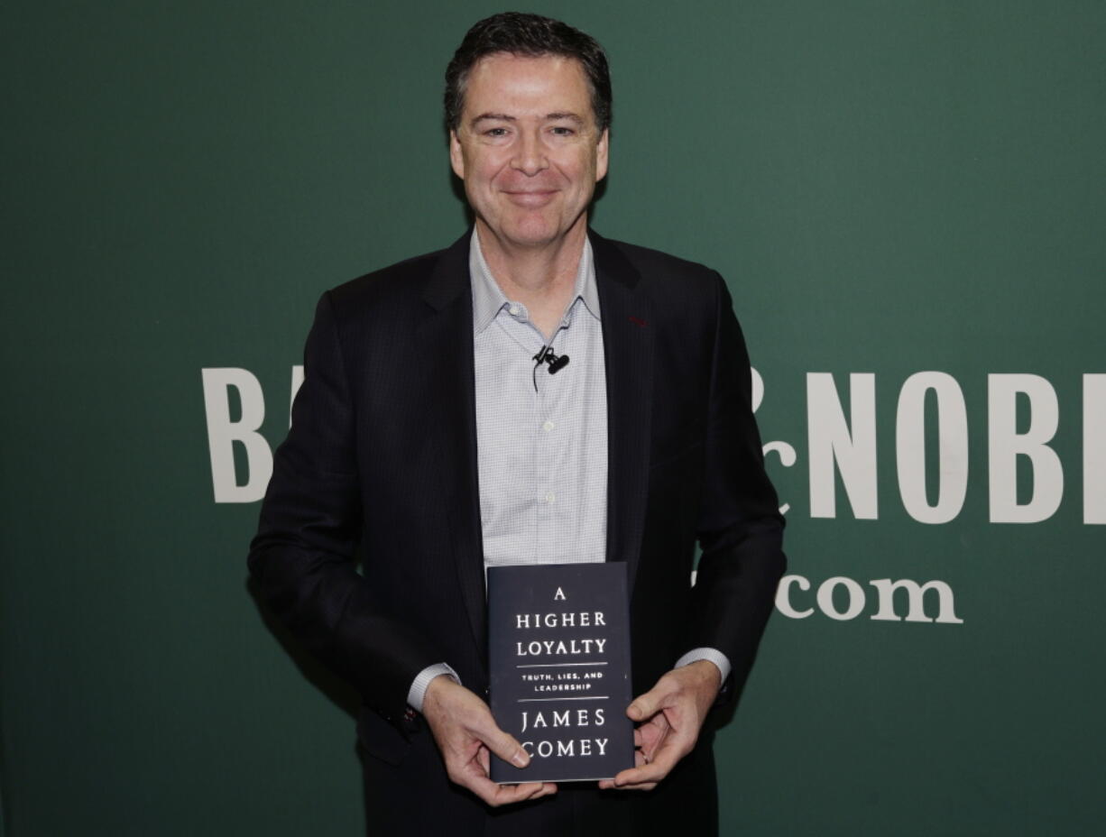 Former FBI director James Comey poses for photographs at a Barnes & Noble book store before speaking Wednesday, April 18, 2018, in New York.