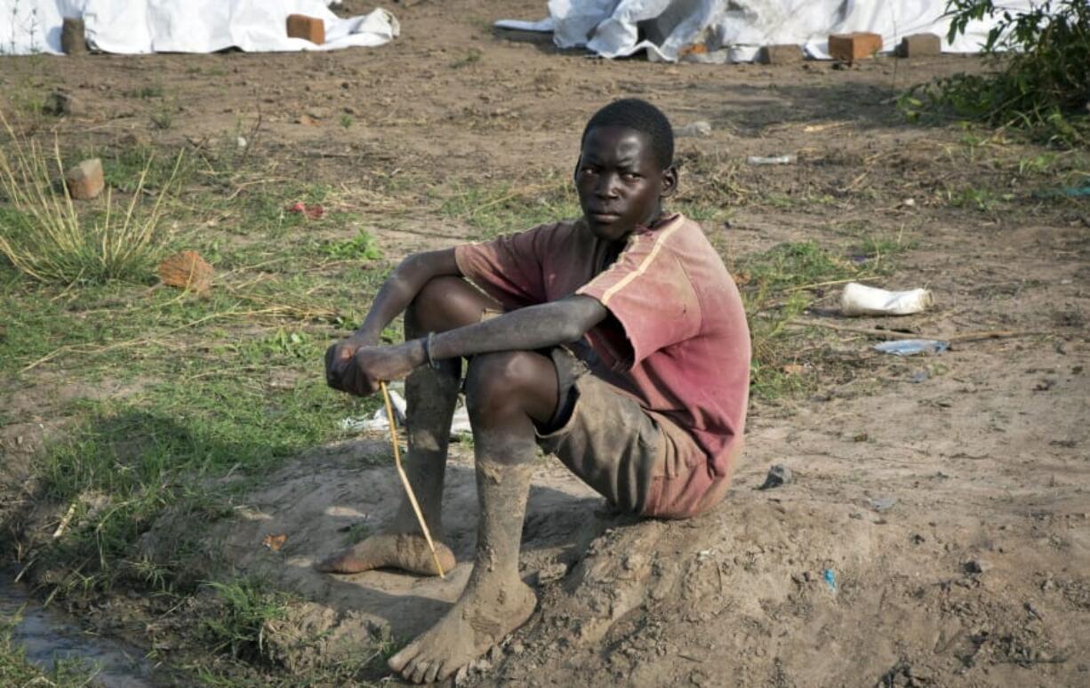 In this photo taken Monday, March 12, 2018, a South Sudanese refugee teenager sits on the ground after making mud bricks in the Rhino refugee settlement, near Arua, in northern Uganda. The flood of South Sudanese refugees from the country’s 5-year civil war has been called a children’s crisis, with more than 60 percent of the well over one million refugees who have poured into neighboring Uganda under the age of 18, officials say.