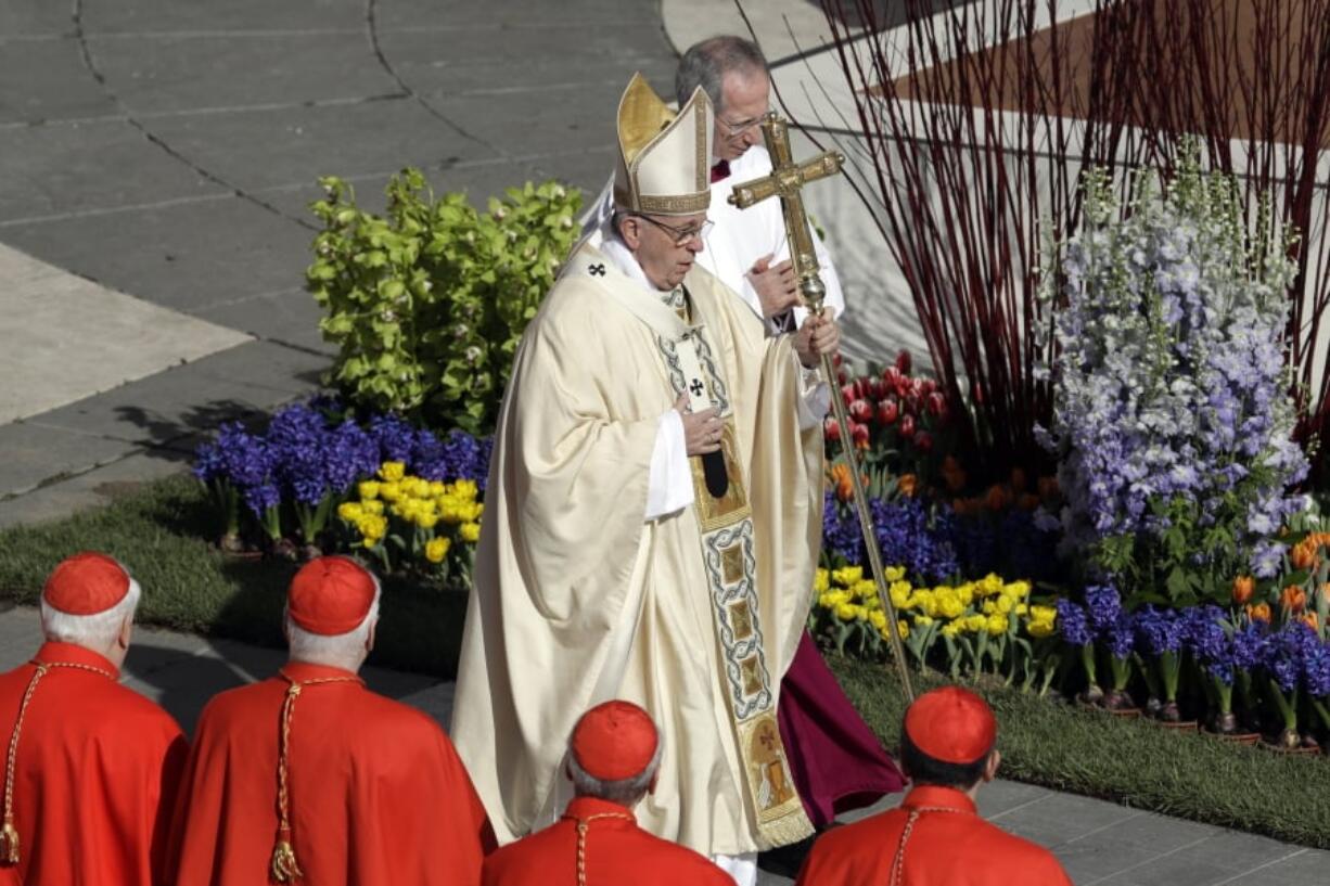 Pope Francis walks with the pastoral staff Sunday as he arrives to celebrates the Easter mass in St. Peter’s Square at the Vatican.