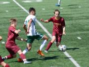 Evergreen forward Elijah Lavin (10) navigates sea of Capital defenders during the Plainsmen's 3A district winner-to-state game at McKenzie Stadium on Saturday, May 12, 2018 (Andy Buhler/Columbian staff).