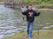 RJ Aparicio, 10, shows off a rainbow trout from Rowland Lake on April 28. Mechanical issues with the hatchery tanker truck meant the lake was not stocked until 11 a.m. on opening day at the Columbia River Gorge lake.