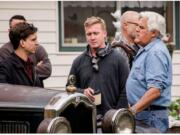 Clayton Paddison, left, a crew member and Jay Leno consult during filming at Paddison’s home on Wednesday morning.