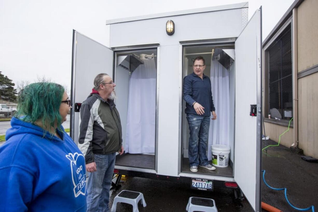 Pastor Brian Norris, right, speaks with volunteers Chuck Goneau and Jamie Spinelli, from Food With Friends as they prepare a mobile showering car for use at the Living Hope Church in Vancouver on Jan. 7. Homeless beneficiaries may receive a hot meal, coffee and a hot shower.