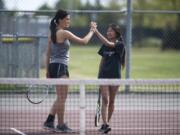 Union’s Nicole Knudtson, left, high fives doubles partner Yannie Li during a match against Camas this season. Knudtson’s promising tennis career has been limited by a bone condition in her left ankle. But that hasn’t stopped her from being one of the state’s top doubles players.