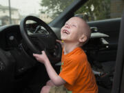 Declan Reagan plays inside his dad’s police cruiser at the Washougal Police Department in Washougal in 2017. A woman from England had donated her bone marrow for his transplant. He died Friday.