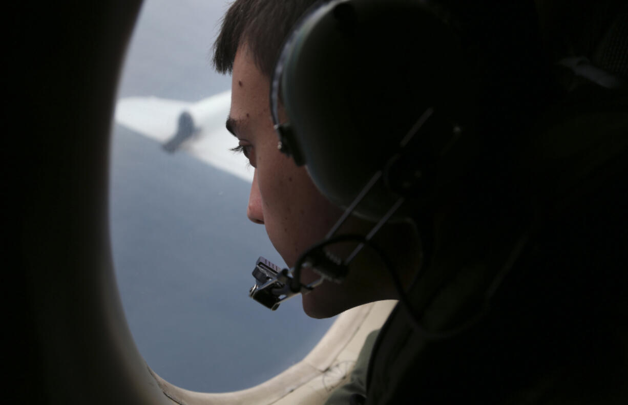 Sgt. Matthew Falanga, on board a Royal Australian Air Force plane, scans the southern Indian Ocean for missing Malaysia Airlines flight MH370 on March 22, 2014.