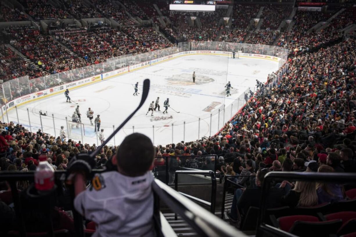 Austin Justin, 5, wears a new jersey from his grandfather, Jim Fich, and holds a toy hockey stick as he cheers on the Winterhawks in Portland in March. When Austin’s mother, Tabitha Fich, was a child, she, her parents and her siblings were regulars at Portland Winterhawks family nights. The family tradition was brought alive again for Austin’s third birthday and he fell in love with the sport. “He just loves watching them skate,” Fich said.