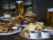 Cheesecake, from left, is served with a burger with blue cheese and bacon and Chips N’ Dips at Grains of Wrath Brewing in Camas.