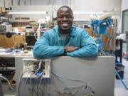 Komivi Akengue, 26, leans on an interactive soccer wall he helped create at ControlTek in Vancouver. The soccer wall, which Akengue worked on in his capstone class at Washington State University Vancouver, provides light-up targets for soccer players and tracks the speed of the ball. Akengue, who is originally from Togo, will be graduating Saturday from WSU Vancouver with a degree in electrical engineering.